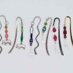 Photo of metal bookmarks available for purchase. This set shows 3 different shiny metal bookmarks with a beaded hanging dangle in various colors with various small animal shaped charm choices for the bottom. Only 1 charm choice per bookmark.