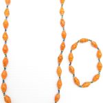 Women's matching beaded necklace and bracelet set in orange with flecks color. Handcrafted with paper beads by Ugandan women artisans.