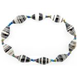 Black & white striped bead bracelet closeup, The stretch bracelet contains 10 paper beads separated by seed beads.