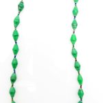 Green with black flecking paper bead necklace on a plain white background. The top of the necklace is not visible.