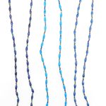 Three blue beaded eyeglass leashes handcrafted from paper beads.