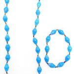 Women's matching beaded necklace and bracelet set in sky blue color. Handcrafted with paper beads by Ugandan women artisans.