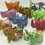 Photo of 7 mini stuffed animal elephants available to purchase. The elephants come in a variety of different colors/patterns of African kitenge cloth.