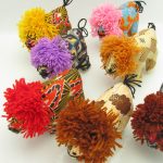 Photo of 7 mini stuffed animal lions available to purchase. The lions come in a variety of different colors/patterns of African kitenge cloth.