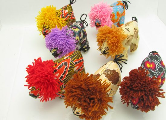 Photo of 7 mini stuffed animal lions available to purchase. The lions come in a variety of different colors/patterns of African kitenge cloth.