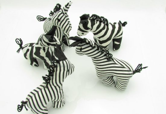 Photo of 7 mini stuffed animal zebras available to purchase. The zebras come in several patterns of black & white stripes.