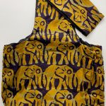 Sling bag in all over deep yellow elephants on a very dark background.