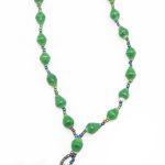 Green lanyard made of paper beads with a small seed bead loop at the bottom and a metal clip to attach your badge. The lanyard is shown on a plain white background. The top of the lanyard is not visible.