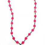 Hot pink lanyard made of paper beads with a small seed bead loop at the bottom and a metal clip to attach your badge. The lanyard is shown on a plain white background. The top of the lanyard is not visible.