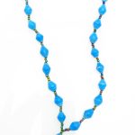 Soft turquoise blue colored lanyard made of paper beads with a small seed bead loop at the bottom and a metal clip to attach your badge. The lanyard is shown on a plain white background. The top of the lanyard is not visible.