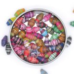 Photo of 50 assorted color striped bi-cone beads that are available to purchase.